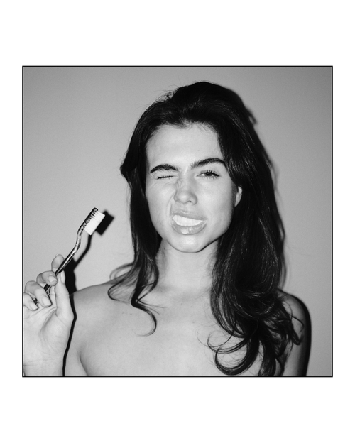 Woman using Natuoral natural fluoride-free hydroxyapatite toothpaste — natural whitening oral care