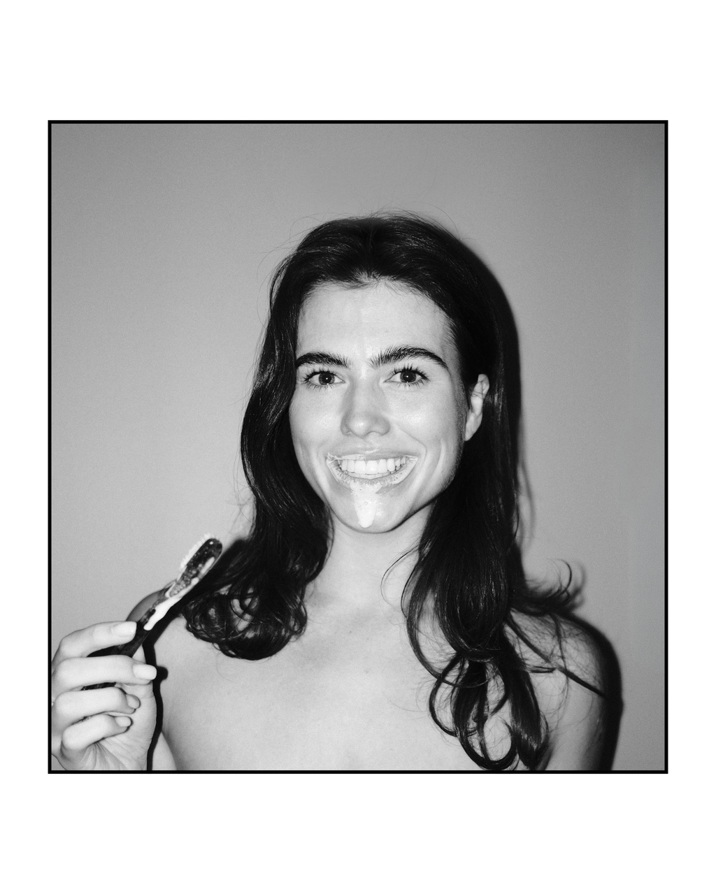 Woman smiling with Natuoral natural toothbrush and fluoride-free hydroxyapatite toothpaste - travel set
